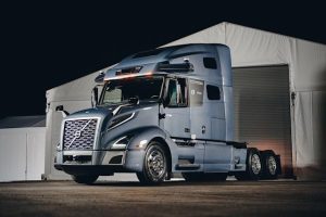 A tractor unit parked in front of a tent at night