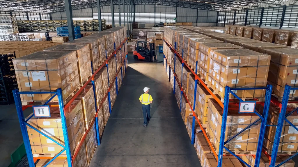 3PL warehouse worker walking around while taking notes of client’s inventory