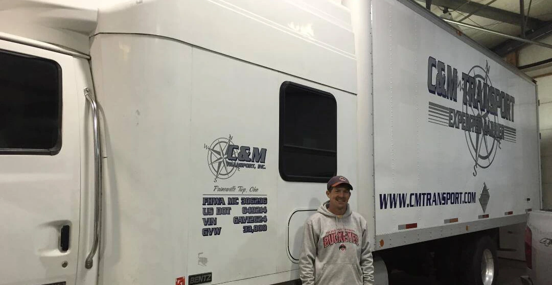 Driver standing in front of C&M Transport truck