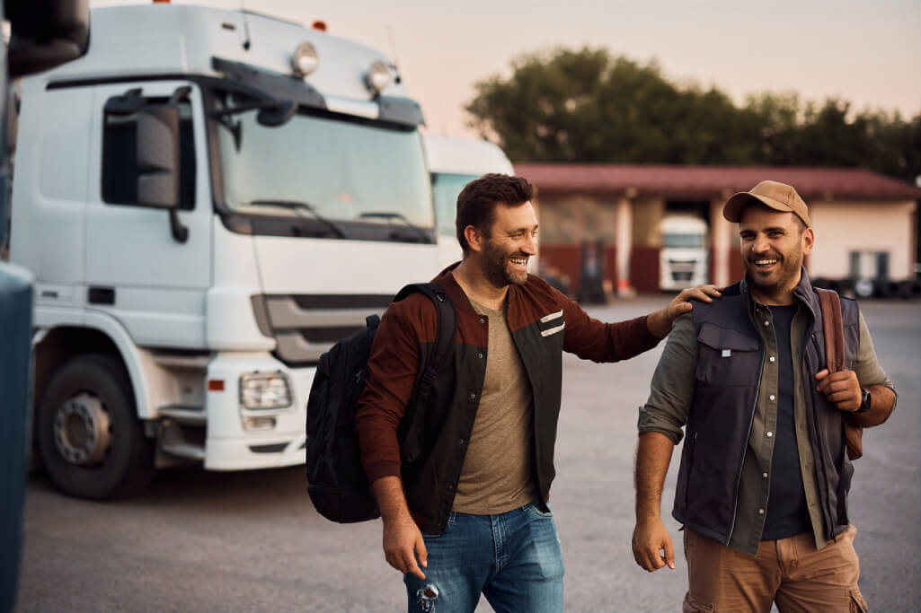 Two truck drivers walking away from truck after long haul