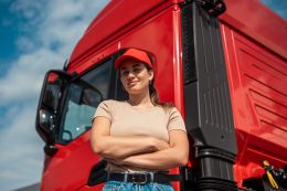 Truck driver in red hat in front of red truck